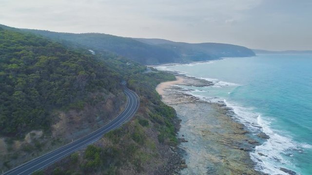 Forward flight over narrow road bends next to the shore