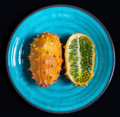 Whole a half kiwano fruit on plate