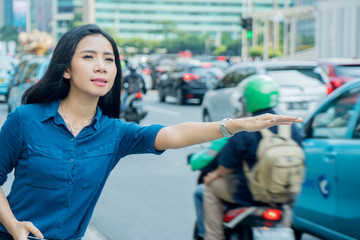 Young woman ordered online cab on the sidewalk