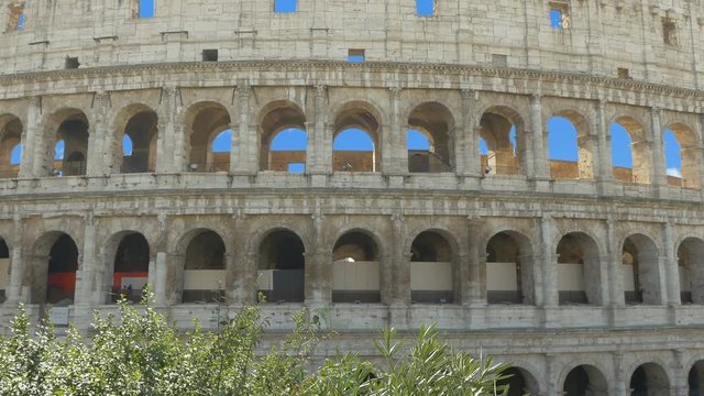 Five year old girl with a phone takes pictures of a Colosseum, family trip to Rome