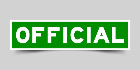 Green color label sticker in word official on gray background
