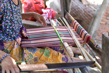 Hands of the Woman weaving on a loom in Sasak Village, Lombok, Indonesia