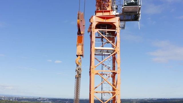 Hook, hoist rope or chains dangling from a tower crane on a residential construction site
