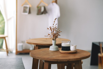 Closeup image of a glass of latte coffee on wooden table in minimal cafe