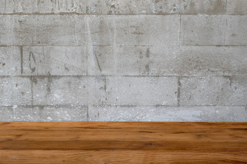 Closeup image of vintage wooden table with concrete wall texture and detail