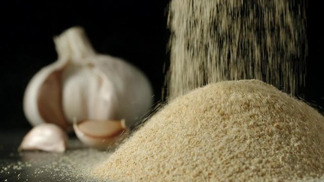 SLOW MOTION:&nbsp;White garlic grains  pouring in a pile