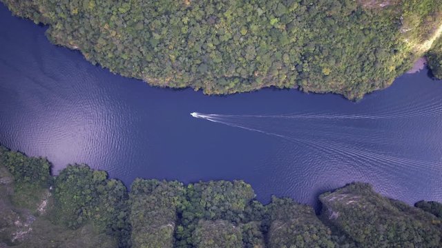Aerial cenital drone shot of a boat sailing in the Grijalva river, Sumidero Canyon, Chiapas Mexico