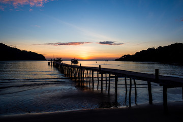 Fototapeta premium Drewniany most na morzu z pięknym zachodem słońca na wyspie koh kood, Tajlandia