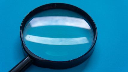 Magnifier glass on blue background
