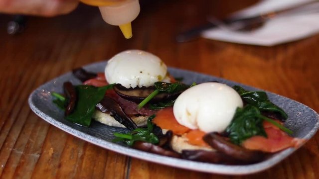 A nice plate of smoked salmon and eggs with saffron mayo on top.
