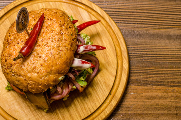 Bacon burger with beef patty on wooden table