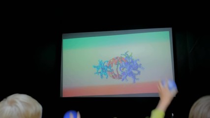 Augmented reality experience - group of children playing educational AR game in front of display at futuristic exhibition. Science, biology, future, medicine and technology concept - Powered by Adobe