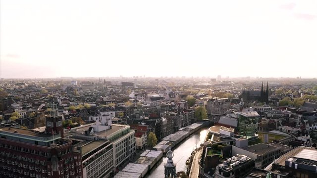 Amsterdam in an aerial shot by drone. The sun is shing over the roofs.
