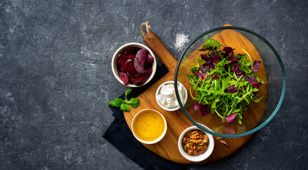 Ingredients for cooking diet summer healthy food top view. preparation salad with baked beets on dark background with copy space