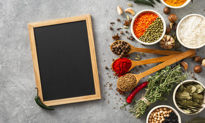 Obraz na płótnie Canvas Menu background. Chalkboard with spices and herbs top view with rice, various beans on white background
