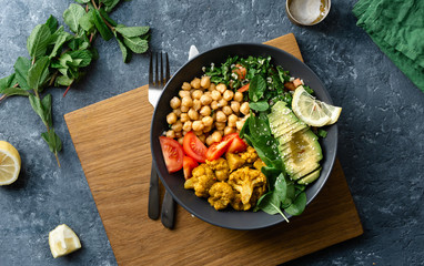 Buddha bowl Vegetarian healthy balanced food Aloo-gobi, chickpeas, tomato, avocado, tabule salad and spinach