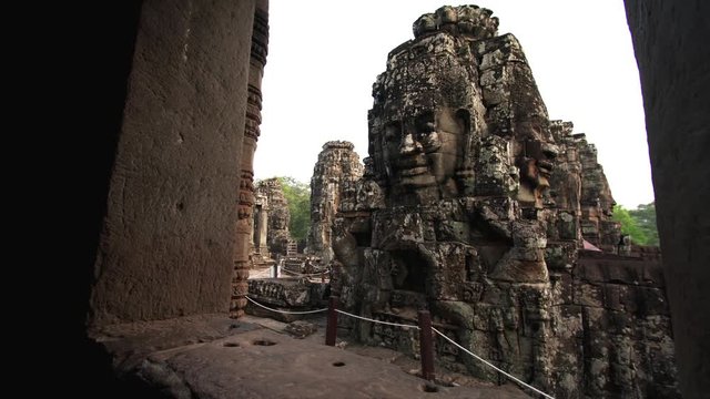 Sliding view from window of giant stone faces depicting Bodhisattva Avalokiteshvara at Bayon Temple, a richly decorated Khmer temple at Angkor in Cambodia
