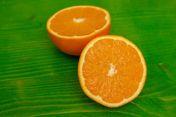 two halves of a ripe orange on green ground