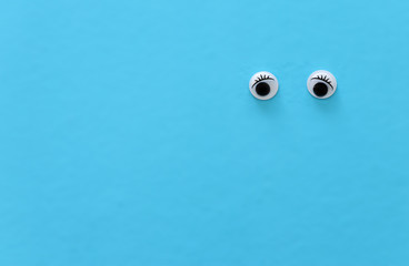 pair googly eyes over blue background