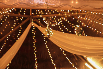 Bokeh of light at white curtain at wedding ceremony