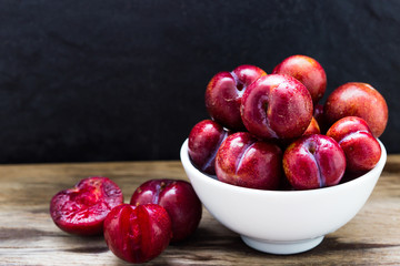 Plums ripe fresh on the wood texture background