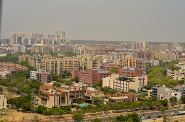 Fototapeta premium Aerial shot Cityscape in Gurgaon, Noida, Jaipur, Delhi, Lucknow, Mumbai, Bangalore, Hyderabad showing small houses, sky scrapers and other infrastructure of the business district in the urban areas. 