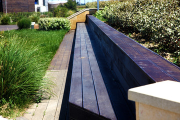 Wooden brown long bench in the park