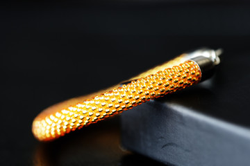 Yellow bracelet made of transparent shiny seed beads on a dark background close up