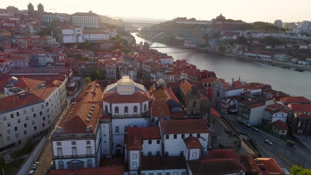 Dron moving down and flying above red tiled roof and towers of Palacio da Bolsa in old town. Aerial shot Porto and ancient buildings in sunny day