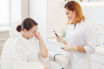 Fototapeta premium Doctor's hands take blood from a vein from a patient sitting in a chair. Blood test concept and detection of diseases