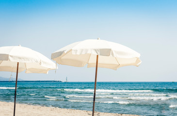 View of the beach of ionic sea near Catania, Sicily, Italy, Lido Cled with white umbrellas