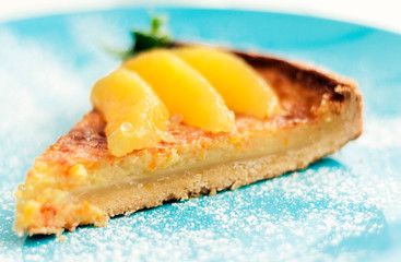 Traditional greek dessert, cake with orange on blue plate.