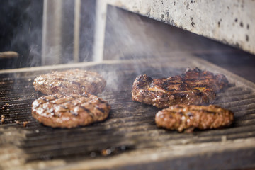 grilled burger cutlet on hot grill with smoke.
