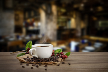 Hot Coffee cup with fresh organic red coffee beans and coffee roasts on the wooden table in the coffee shop background