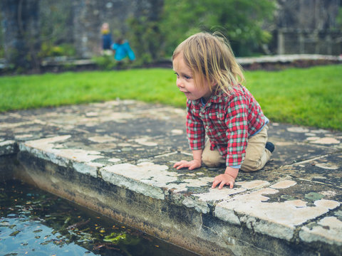 Little toddler looking at a pond