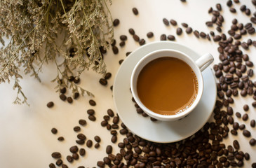 Coffee in white glass and coffee beans on a white background