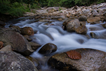 Naklejka na ściany i meble Rocks in stream with smooth flowing water