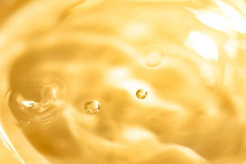 金色の液体・水・テクスチャ。美容や健康イメージ。