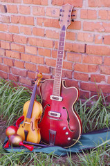 Musical instruments: guitar, violin. maracas tambourine flute on brick wall background
