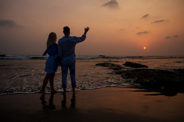 Young couple in love on the beach February 14, St. Valentine's Day sunset Goa India vacation trip .travel new year in a tropical country. freedom concept