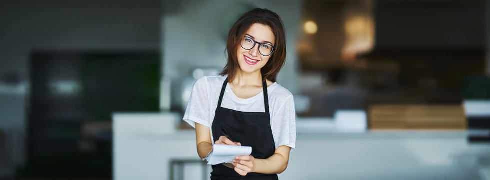 young waitress ready to take order on notepad in restauran