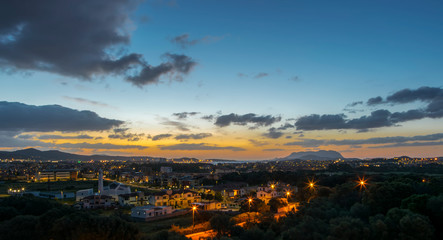 Fototapeta na wymiar Vista panoramica di Olbia all'alba, sullo sfondo l'isola di Tavolara e il Porto, in basso a sinistra la Parrocchia di San Michele Arcangelo, Sardegna 