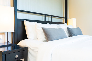 Beautiful luxury comfortable pillow on bed with light lamp