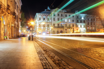 Fototapeta na wymiar Lviv panorama at night. View of the night street of the European medieval city. Lviv Market square at night. Concept - travel, landmarks. FROZEN LIGHT FROM TRAM. Long exposure