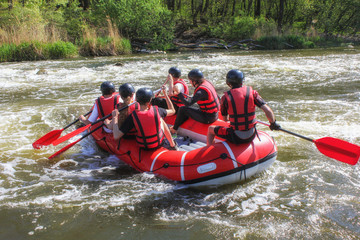  Rafting team , summer extreme water sport.  Group of people in a rafting boat, beautiful...
