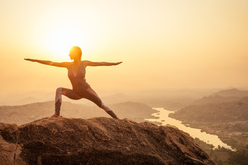 Yoga in Hampi temple copyspase at sunset.travel vacation copy spase lady with stylish jumpsuit