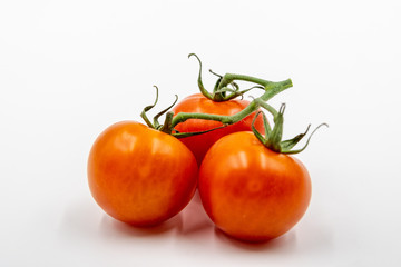 Three red tomatoes with branch