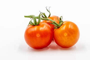 Three red tomatoes with branch