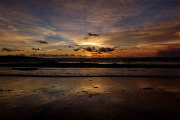 the beauty of Jimbaran beach in Bali Indonesia at dusk with the sun disappearing