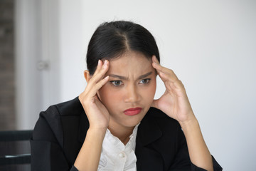 Portrait of frustrated young woman holding hand on head